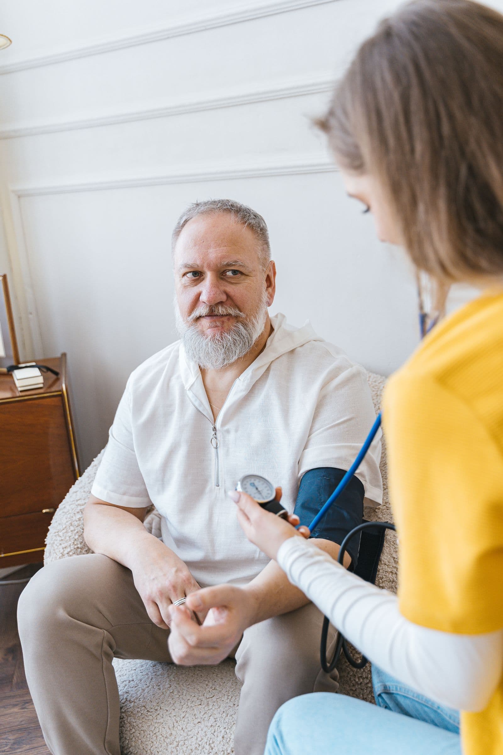 Caregiver taking a patient's blood pressure at home